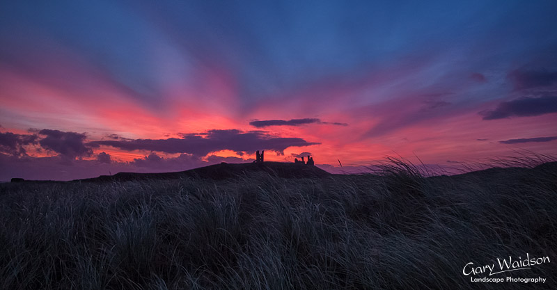 Dunstanburgh castle at sunrise. Landscape photography by Gary Waidson.